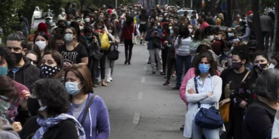 In langen Schlangen stehen die Menschen in Chiles Hauptstadt an, um ihre Stimmen abzugeben. Foto: Esteban Felix/AP/dpa