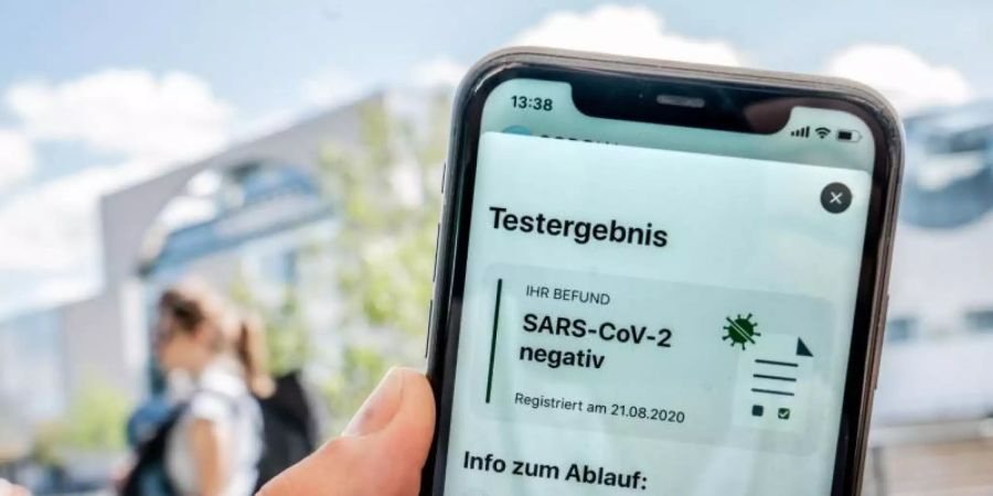 Ein für einen Reiserückkehrer durchgeführter Corona-Test wird auf dem Display eines iPhone in der Corona-Warn-App als "negativ" dargestellt. Foto: Michael Kappeler/dpa