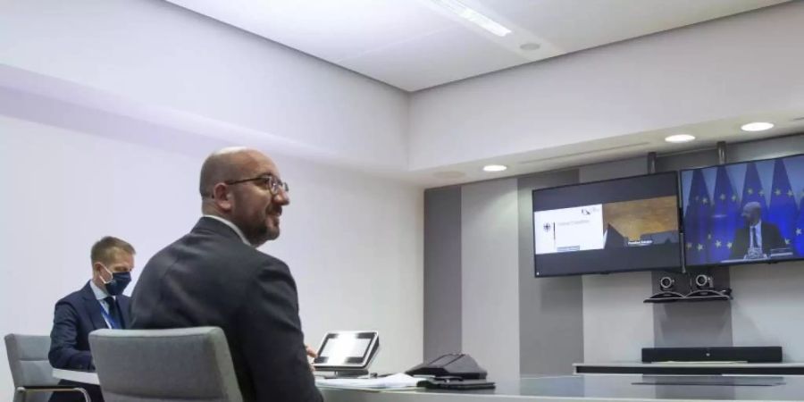 Charles Michel (vorne), Präsident des Europäischen Rates, wartet auf den Beginn eine Videokonferenz. Foto: Aris Oikonomou/Pool AFP/AP/dpa