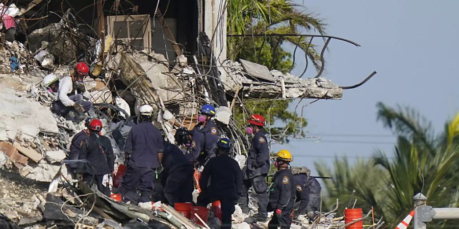 Rettungskräfte durchsuchen die Trümmer des Champlain Towers. Nach dem Teileinsturz eines zwölfstöckigen Wohnhauses im US-Bundesstaat Florida sind in den Trümmern weitere Todesopfer gefunden worden. Foto: Lynne Sladky/AP/dpa