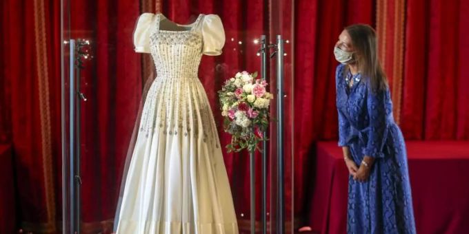Caroline de Guitut, Kuratorin des Royal Collection Trust, wirft einen Blick auf das Hochzeitskleid von Prinzessin Beatrice. Foto: Steve Parsons/PA Wire/dpa Caroline de Guitut, Kuratorin des Royal Collection Trust, wirft einen Blick auf das Hochzeitskleid von Prinzessin Beatrice. Foto: Steve Parsons/PA Wire/dpa