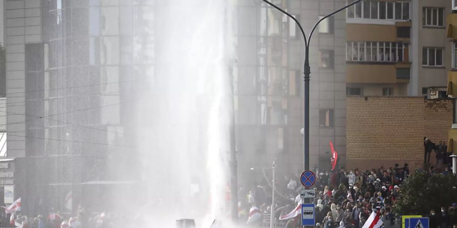 Polizisten setzten einen Wasserwerfer gegen Demonstranten ein. Trotz eines Grossaufgebots an Sicherheitskräften haben Zehntausende Menschen gegen den autoritären Staatschef Lukaschenko demonstriert. Foto: Uncredited/AP/dpa