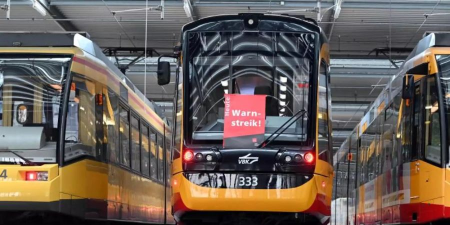 An einer Strassenbahn der Verkehrsbetriebe Karlsruhe hängt ein Plakat mit der Aufschrift Warnstreik. D. Foto: Uli Deck/dpa