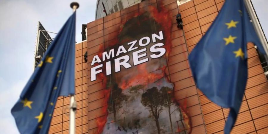 Klimaaktivisten haben ein riesiges Transparent an der Fassade des Hauptsitzes der Europäischen Kommission platziert. Foto: Francisco Seco/AP/dpa