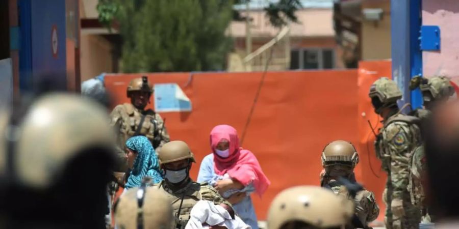 Sicherheitskräfte und Gesundheitspersonal mit Schutzmasken tragen Babys aus einem Krankenhaus nach einem Anschlag in Kabul. Foto: Rahmatullah Alizadah/XinHua/dpa