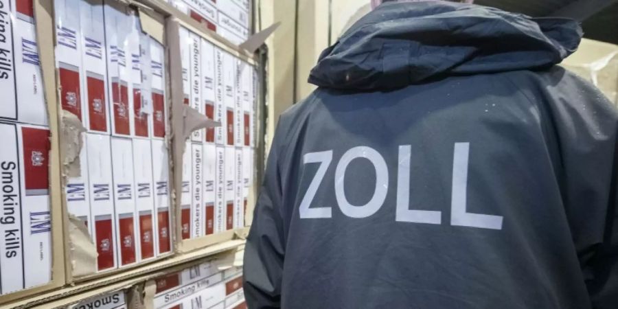 Zollbeamter mit Schmuggelzigaretten
