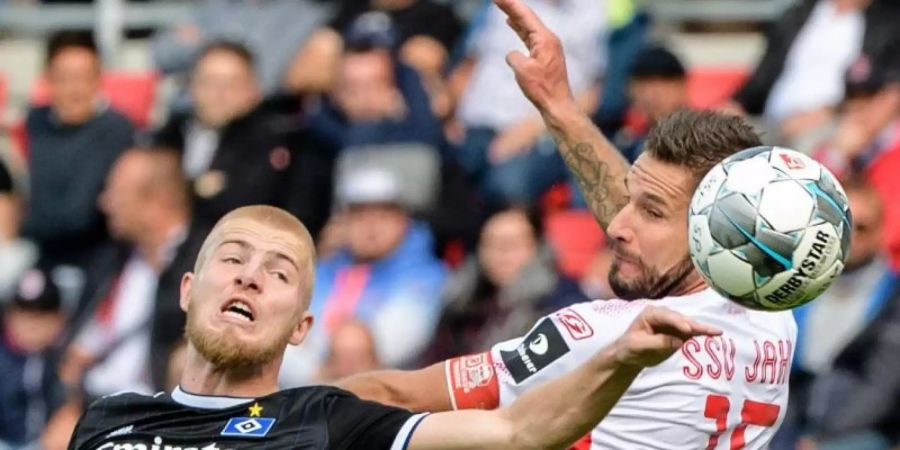 Rick van Drongelen (l) vom HSV im Kopfballduell mit Regensburgs Marco Grüttner. Foto: Matthias Balk