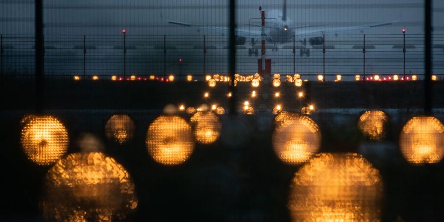 Ein Flugzeug landet hinter Signallichtern auf dem Flughafen Frankfurt. Die Flughafengesellschaft Fra