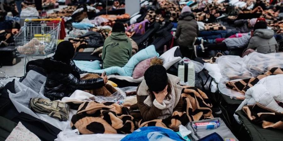 Menschen ruhen sich in einem Einkaufszentrum in Mylny aus, das für die vorübergehende Aufnahme von Flüchtlingen aus der Ukraine bestimmt ist. Foto: Alejandro Martínez Vélez/EUROPA PRESS/dpa
