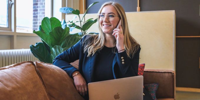 Telefon hier, Telefon da: Im Job kann es manchmal ganz schön stressig werden. Frau am Telefon