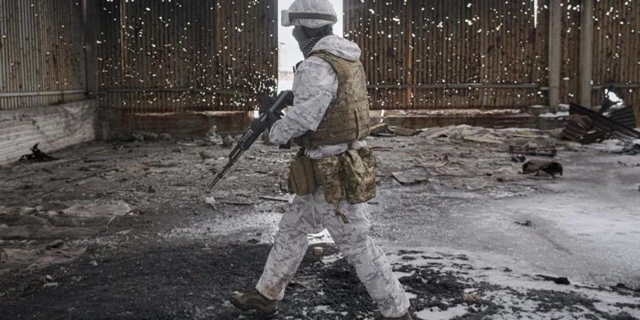 Ein ukrainischer Soldat geht durch eine zerstörte Lagerhalle an der Frontlinie in der Region Donezk. Foto: Vadim Ghirda/AP/dpa