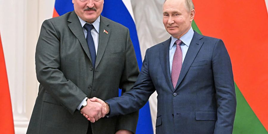 Wladimir Putin (r), Präsident von Russland, und Alexander Lukaschenko, Präsident von Belarus, geben sich nach einer gemeinsamen Pressekonferenz nach ihren Gesprächen im Kreml die Hand. Foto: Sergei Guneyev/Pool Sputnik Kremlin/AP/dpa