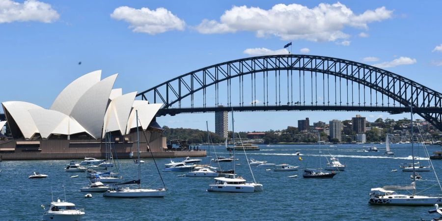 Sportboote liegen im Hafen von Sydney vor dem Opernhaus und der Sydney Harbour Bridge.
