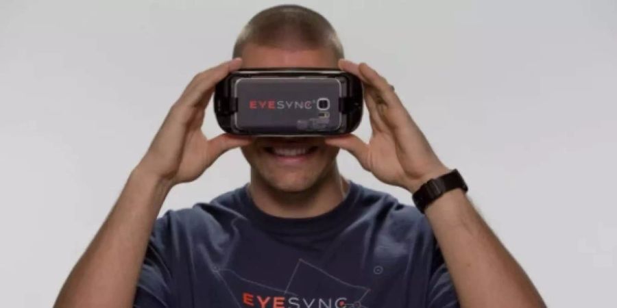 Ein Sportler posiert mit einer VR-Brille von SyncThink.