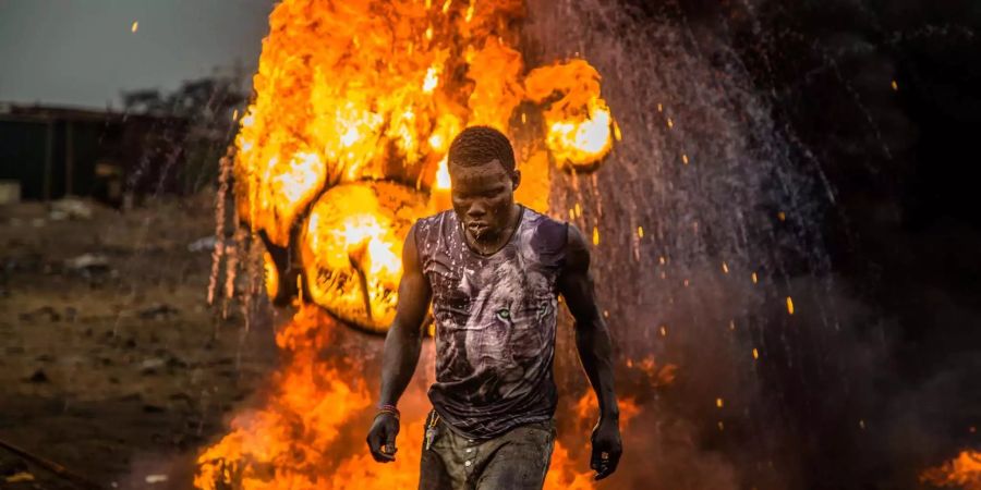 Ein Ausschnitt aus dem Film «Welcome to Sodom», in dem ein Mann vor einem Feuer steht.