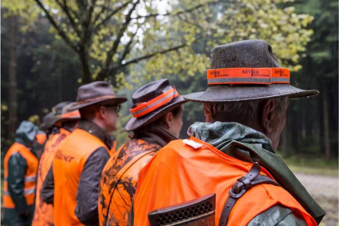 Jäger stehen in einer Reihe, alle mit Hüten und Leuchtvesten - Keystone Jäger stehen in einer Reihe, alle mit Hüten und Leuchtvesten - Keystone