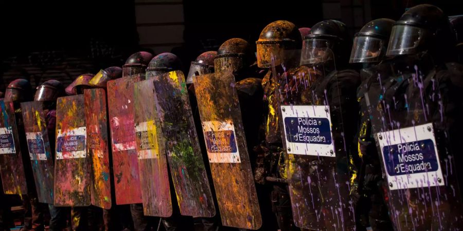 Katalanische Polizisten stellen sich in eine Reihe bei Demonstrationen in Barcelona. Demonstranten bewarfen sie mit Farbe.