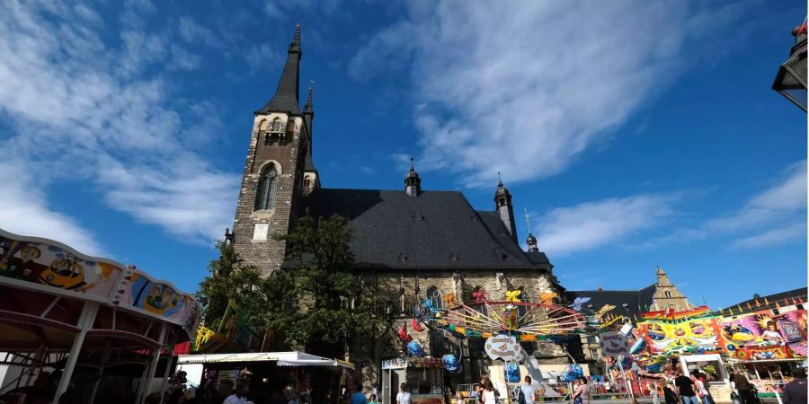 Kirmes-Geschäfte stehen vor der St.-Jacob-Kirche, in der eine Andacht für einen getöteten 22-Jährigen gehalten wird.