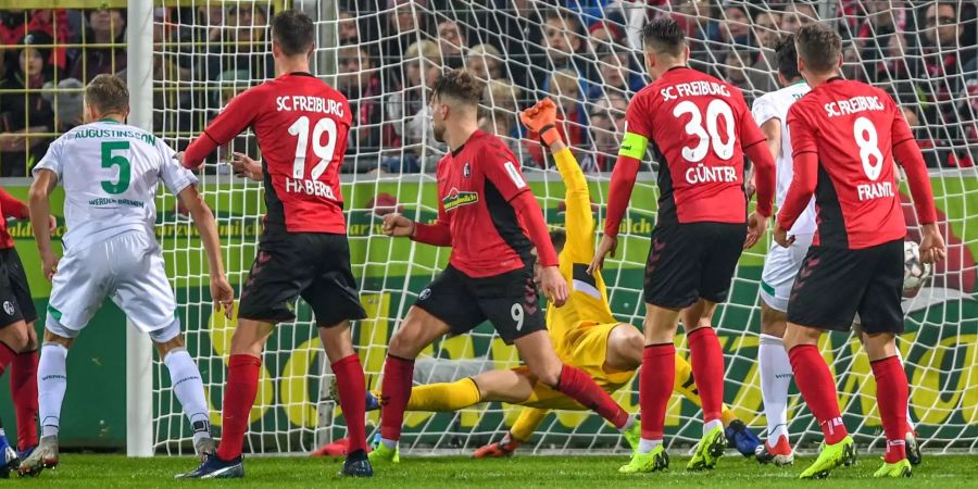 Ludwig Augustinsson (links) von Bremen erzielt das 1:1 gegen Torwart Alexander Schwolow von Freiburg.