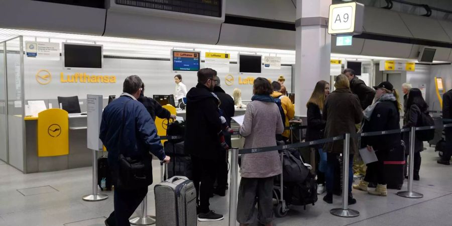 Fluggäste der Fluggesellschaft Lufthansa warten im Terminal auf die Abfertigung.