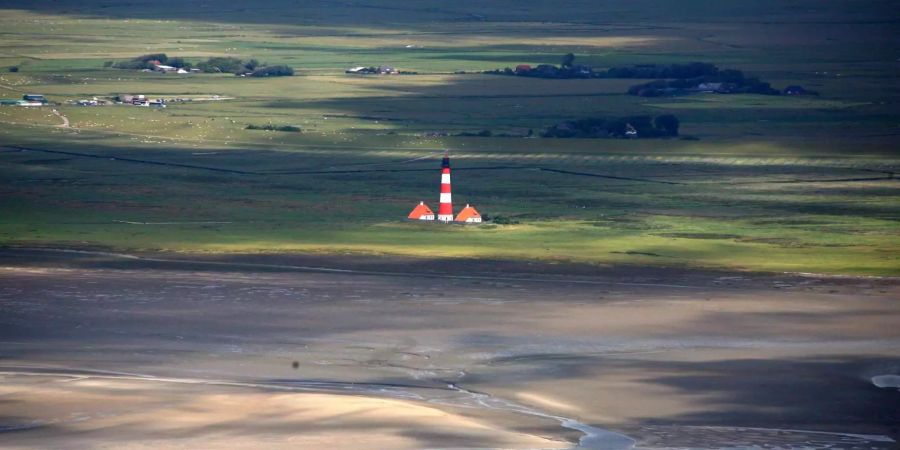 Blick bei Niedrigwasser auf das Wattenmeer und den Leuchtturm von Westerheversand an der schleswig-holsteinischen Nordseeküste. Das Wattenmeer muss nach Ansicht von Bundesumweltministerin Schulze (SPD) eine Tabuzone für den Bau von Windparks bleiben.