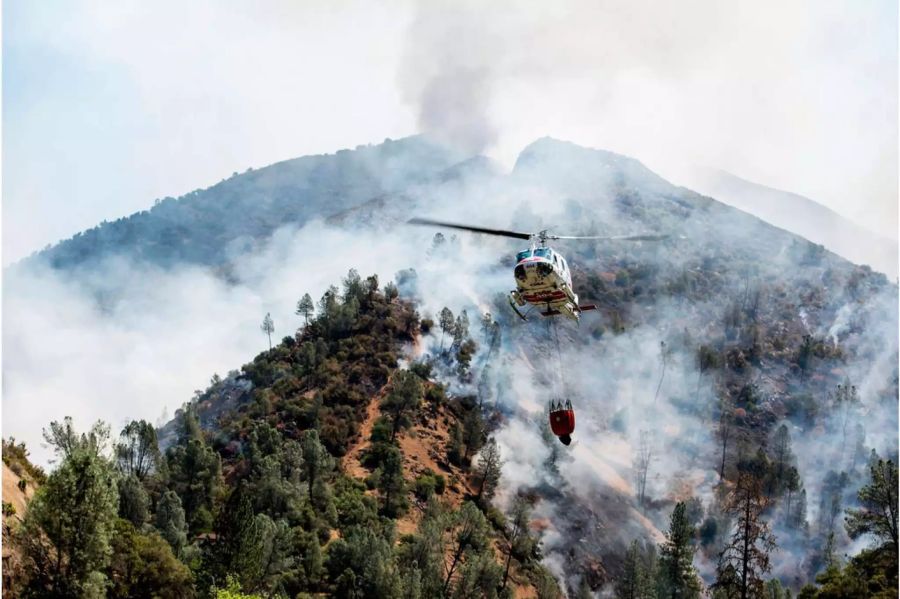 Ein Helikopter sammelt Wasser aus dem Merced River, um das Feuer zu bekämpfen.