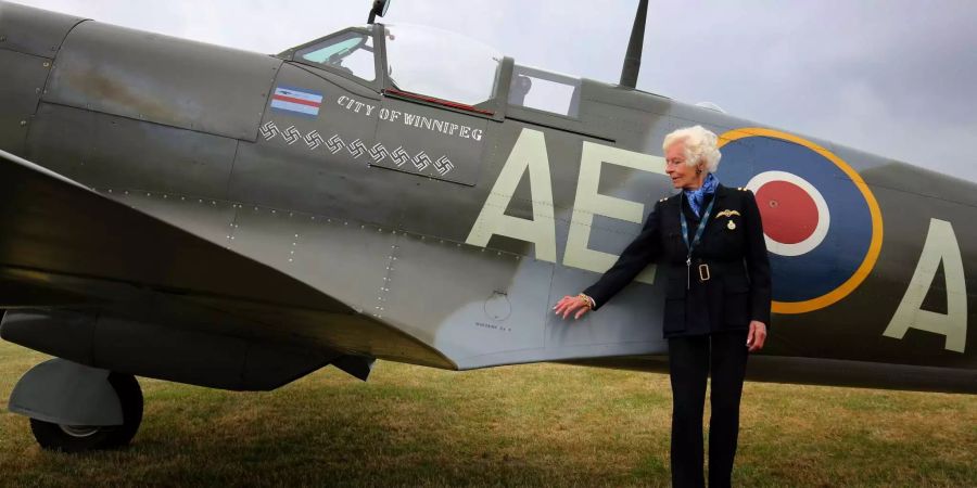 Die britische Weltkriegspilotin Mary Ellis betracht auf dem London Biggin Hill Airport ein Flugzeug des Typs Spitfire.