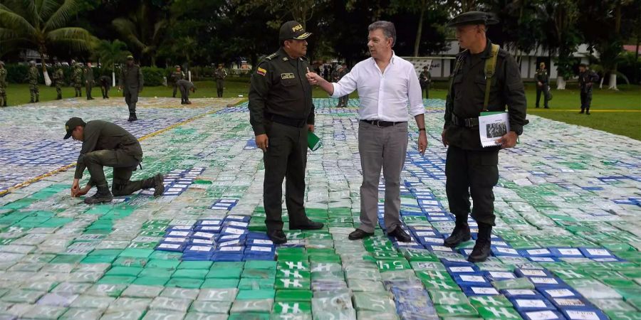 Der kolumbianische Präsident Juan Manuel Santos und General Jorge Nieto (l) stehen in Antioquia auf einem grossen Kokainfund.