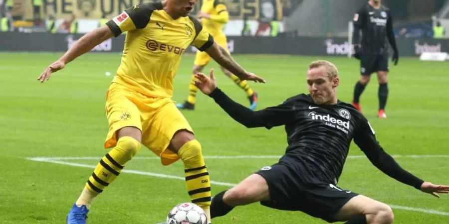 Der Dortmunder Jadon Sancho (l) wird von Frankfurts Sebastian Rode im Dribbling bedrängt. Foto: Thomas Frey