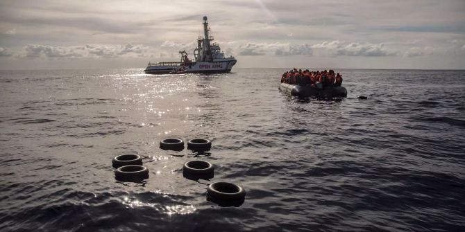 Migranten sitzen in einem Schlauchboot im Mittelmeer.