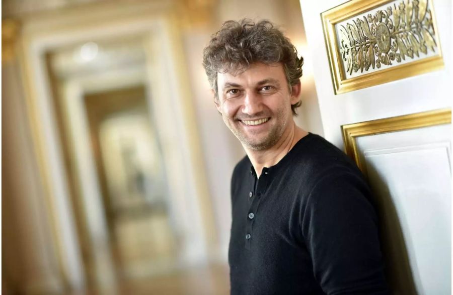 Der Opernsänger Jonas Kaufmann lacht in der Staatsoper in die Kamera.