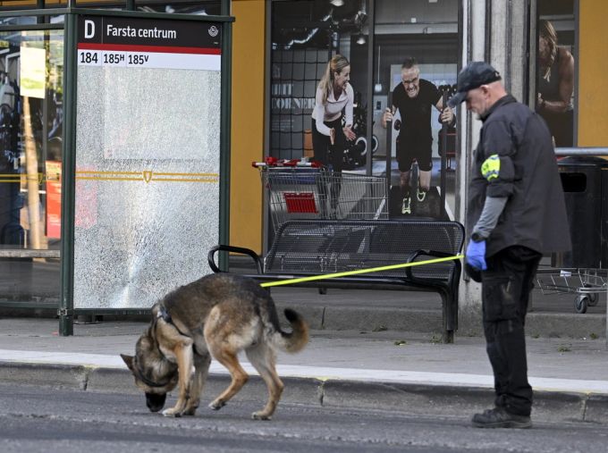Ein Polizeibeamter mit einer Hundestaffel arbeitet am Tatort in Farsta. Polizeihund untersucht Tatort