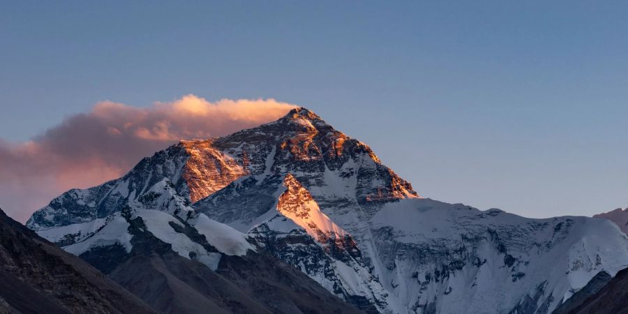 Der Sonnenuntergang färbt den Gipfel des Mount Everest.