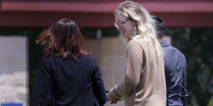 Die verurteilte Theranos-Geschäftsführerin Elizabeth Holmes (Mitte) wird von Gefängnisbeamten in ein Bundesgefängnis für Frauen in Texas eskortiert. (AP Photo/Michael Wyke) elizabeth holmes