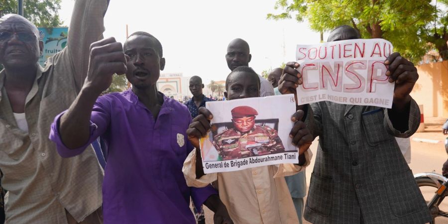Menschen mit Plakaten des Putschisten General Omar Tchiani
in Niamey.