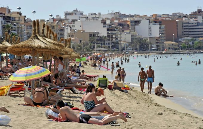 Touristen liegen am Stand von Playa de Palma in Mallorca. mittelmeer