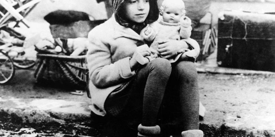 Ein Mädchen mit ihrer Puppe im Arm auf einem Flüchtlingstreck im Jahr 1945.