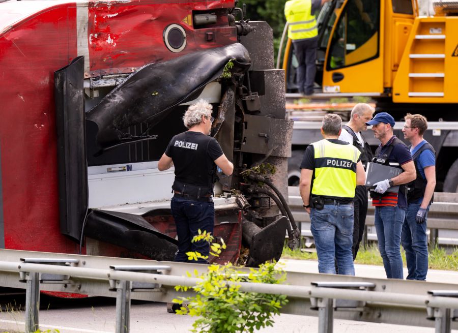 Polizisten untersuchen am zweiten Tag nach einem schweren Zugunglück einen Eisenbahnwagen.