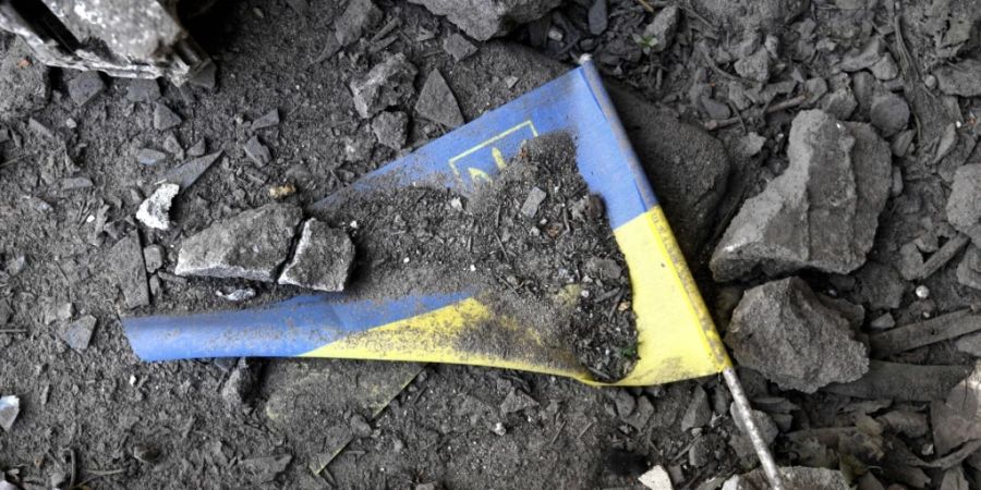 Eine ukrainische Fahne liegt nach einem Raketeneinschlag in den Trümmern einer Schule in Charkiw. Foto: Carol Guzy/ZUMA Press Wire/dpa