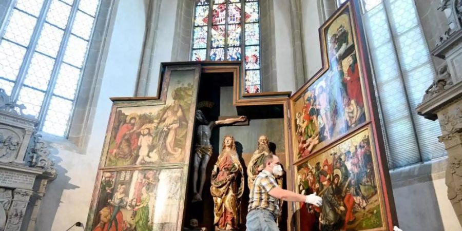 Um ein möglicherweise neu entdecktes Werk von Albrecht Dürer sichtbar zu machen, klappen Kirchenmitarbeiter der Johanneskirche ihren spätgotischen Flügelaltar zu. Foto: Bernd Weissbrod/dpa