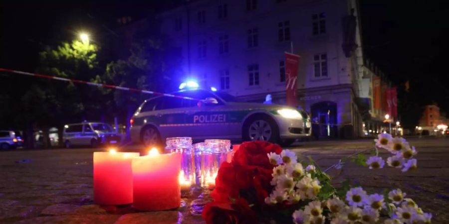 Kerzen und Blumen nahe des Tatorts in der Würzburger Innenstadt. Foto: Karl-Josef Hildenbrand/dpa