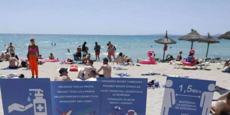 Touristen halten sich am Strand von Arenal in Palma de Mallorca auf. Foto: Clara Margais/dpa