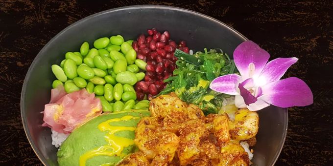 Gebratene Crevetten mit Knoblauh-Chili-Flakes, Avocado, Wakame, Edamame, Granatapfelkerne, Sushi-Ingwer und Mango Topping. Angerichtet auf Sushi Reis. Maori
