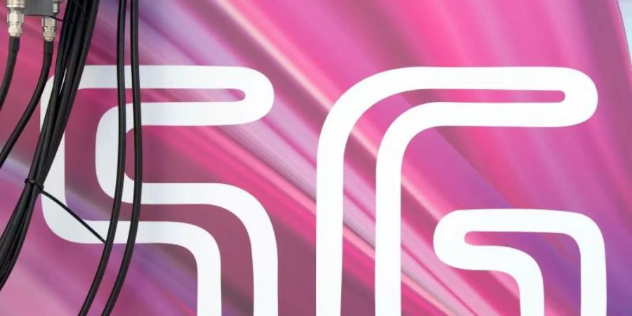 Antennenkabel verlaufen vor dem Schriftzug «5G». Foto: Sebastian Kahnert/dpa-Zentralbild/dpa