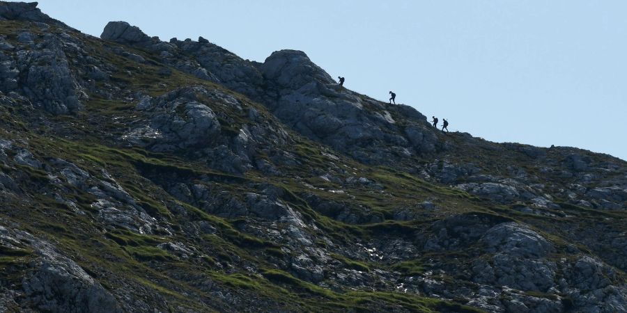 Wanderer in Bayern steigen einen Grat hinauf.