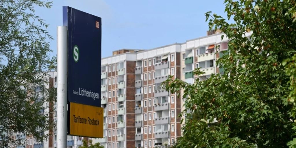 Mann an Wohnungsfenster in RostockLichtenhagen mit ätzender