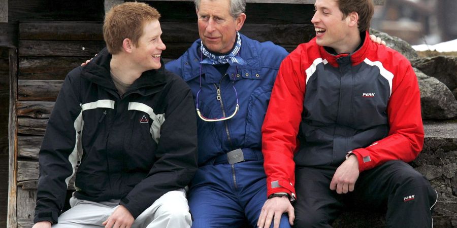 Prinz Charles (M) spricht mit seinen Söhnen Harry (l) und William während eines Fototermins in der Nähe des Ferienorts Klosters (2005).