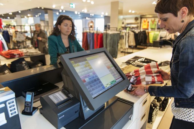 Eine Kundin zahlt an der Kasse. Mode