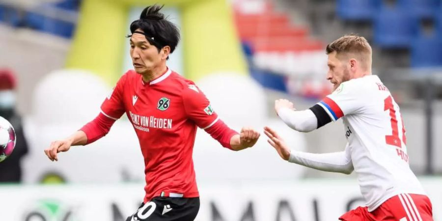Genki Haraguchi (l) brachte Hannover gegen den HSV mit Dreifach-Torschütze Aaron Hunt wieder zurück ins Spiel. Foto: Swen Pförtner/dpa-POOL/dpa