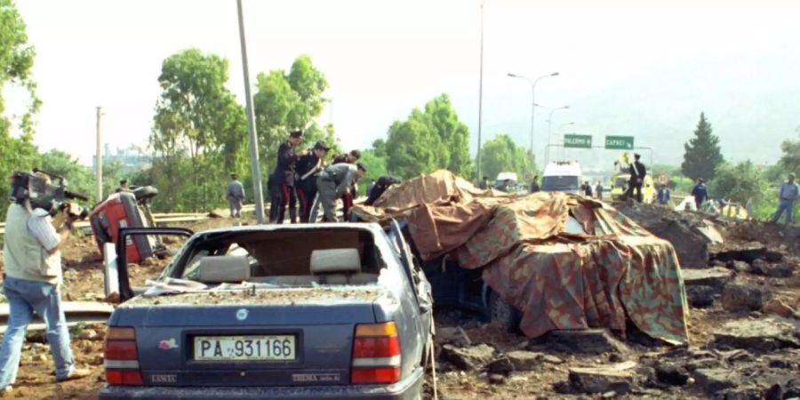 ARCHIV - Duch eine Bombenexplosion zerstörte Autowracks stehen am 23.05.1992 auf der Strasse bei Palermo. Durch die Explosion wurde der Top-Mafia-Jäger Giovanni Falcone, seine Frau und drei Polizisten, die sie begleiteten, getötet. Foto: Nino Labruzzo/AP/dpa